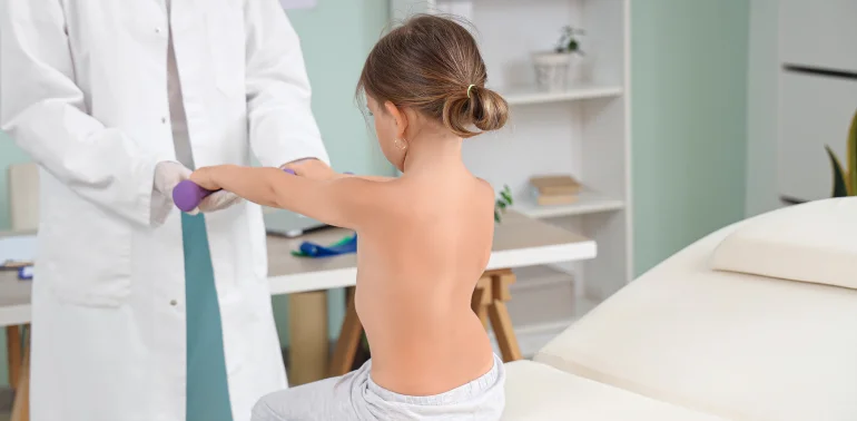 Physiotherapist providing pediatric posture disorder physiotherapy treatment at home in Karachi